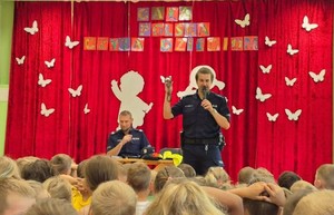 sala, dzieci siedzą i oglądają wystąpienie policjantów