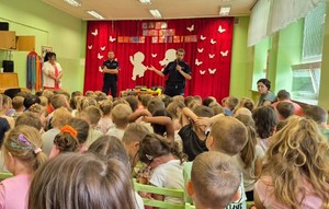 sala, dzieci siedzą i oglądają wystąpienie policjantów