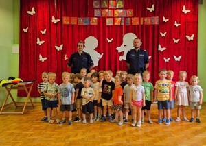 dzieci pozują do zdjęcia z policjantami