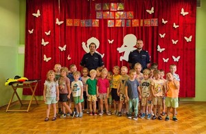 dzieci pozują do zdjęcia z policjantami