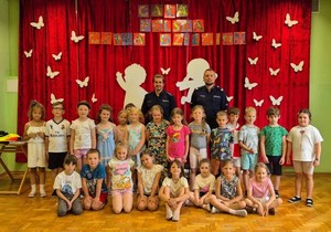 dzieci pozują do zdjęcia z policjantami