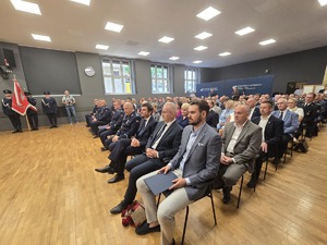 osoby zgromadzone na sali, siedzą i obserwuja sceną