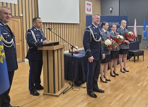 osoba stoi za mównicą i przemawia do zgromadzonych gości