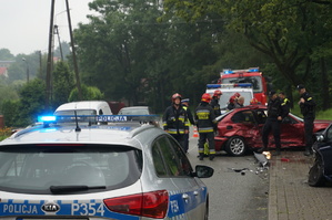 dzień, pochmurno, miejsce zdarzenia drogowego-pojazdy służb policji i straży oraz rozbity samochód