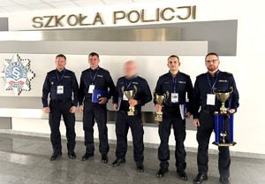 policjanci pozują do zdjęcia z pucharem i dyplomami