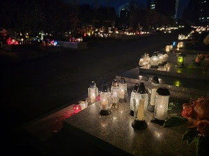 zapalone znicze na cmentarzu, noc