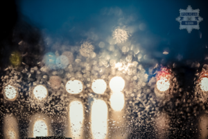 widok w nocy na drogę poprzez szybę zmoczona deszczem