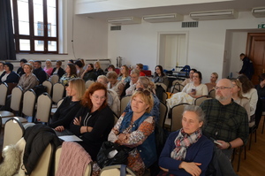 zdjęcia z sali, prelegenci przemawiają, osoby zgromadzone siedzą na krzesłach i słuchają ,