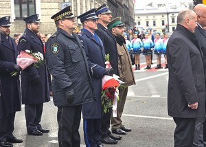 osoby maszerują, dużo flag Polski, pochmurno, widać poczet sztandarowy
