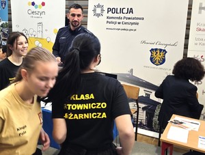 młodzież ogląda stoisko policji na targach, sala gimnastyczna