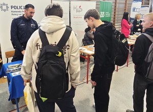 młodzież ogląda stoisko policji na targach, sala gimnastyczna