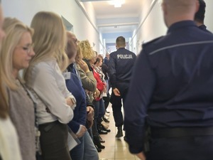 osoby stoją na korytarzu