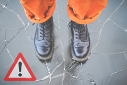 zdjęcie nóg osoby, która stoi na pękniętym lodzie