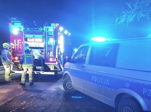 samochody policji  i straży pożarnej z włączonymi światłami uprzywilejowania, noc