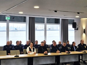 sala sesyjna, sztuczne światło, samorządowcy i policjanci zgromadzeni na sali siedzą i oglądają prezentację