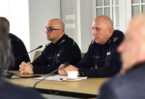 sala sesyjna, sztuczne światło, samorządowcy i policjanci zgromadzeni na sali siedzą i oglądają prezentację