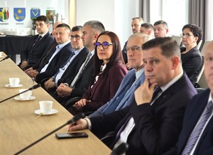 sala sesyjna, sztuczne światło, samorządowcy i policjanci zgromadzeni na sali siedzą i oglądają prezentację