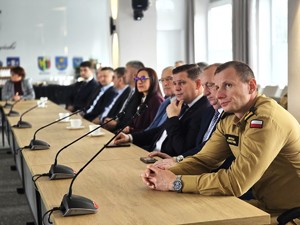 sala sesyjna, sztuczne światło, samorządowcy i policjanci zgromadzeni na sali siedzą i oglądają prezentację