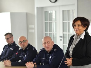 sala sesyjna, sztuczne światło, samorządowcy i policjanci zgromadzeni na sali siedzą i oglądają prezentację