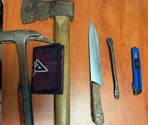 zdjęcie zabezpieczonych niebezpiecznych narzędzi-noże oraz siekiera, ułożone na stole