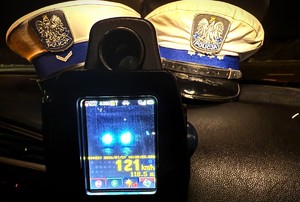 policyjne czapki na podszybiu samochodu, zdjęcie fotoradaru prezentujące prędkość 121 kilometrów na godzinę