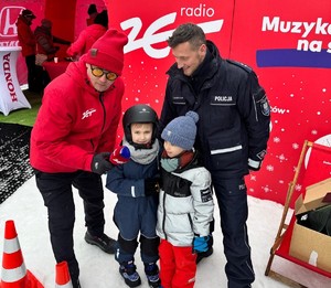 dzień, śnieg, zima, policjanci oraz osoby na stoku, rozmawiają ,uśmiechają się