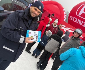 dzień, śnieg, zima, policjanci oraz osoby na stoku, rozmawiają ,uśmiechają się