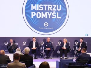 osoby siedzą na podium i rozmawiają