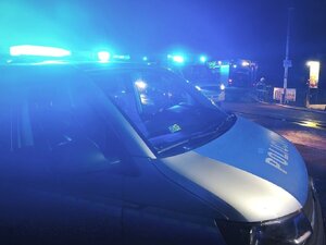 pojazd służbowy Policji z włączonymi sygnałami świetlnymi