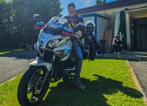 mężczyzna na motocyklu policyjnym, pozuje do zdjęcia