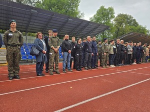 komendant i organizatorzy wręczają nagrody uczestnikom na stadionie, wszyscy uśmiechnięci