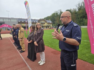 komendant i organizatorzy wręczają nagrody uczestnikom na stadionie, wszyscy uśmiechnięci