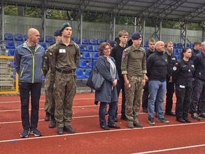 komendant i organizatorzy wręczają nagrody uczestnikom na stadionie, wszyscy uśmiechnięci