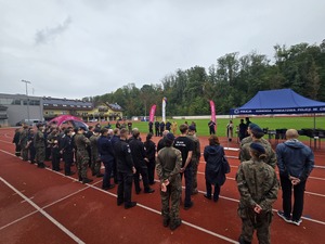 komendant i organizatorzy wręczają nagrody uczestnikom na stadionie, wszyscy uśmiechnięci