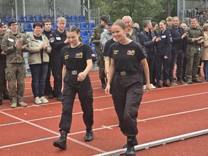 komendant i organizatorzy wręczają nagrody uczestnikom na stadionie, wszyscy uśmiechnięci