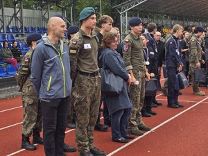 komendant i organizatorzy wręczają nagrody uczestnikom na stadionie, wszyscy uśmiechnięci