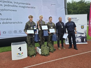 komendant i organizatorzy wręczają nagrody uczestnikom na stadionie, wszyscy uśmiechnięci