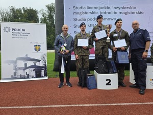 komendant i organizatorzy wręczają nagrody uczestnikom na stadionie, wszyscy uśmiechnięci