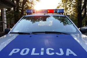 samochód policji, napis policja, w tle zachodzące słońce