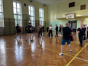 osoby trenują sporty walki na hali sportowej