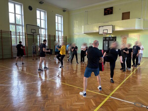 osoby trenują sporty walki na hali sportowej