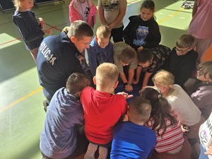 policjanci i ratownicy uczą udzielać dzieci pierwszej pomocy na manekinie- resuscytacja