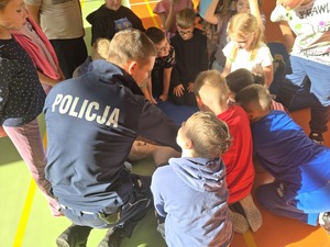 policjanci i ratownicy uczą udzielać dzieci pierwszej pomocy na manekinie- resuscytacja
